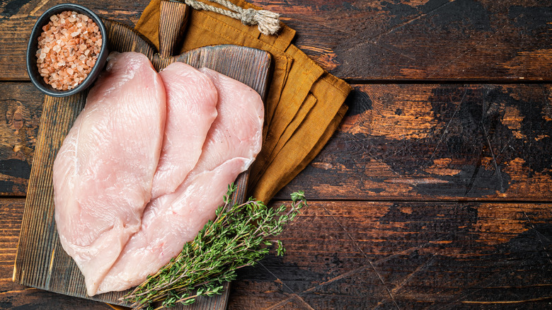 Raw chicken cutlets on tray