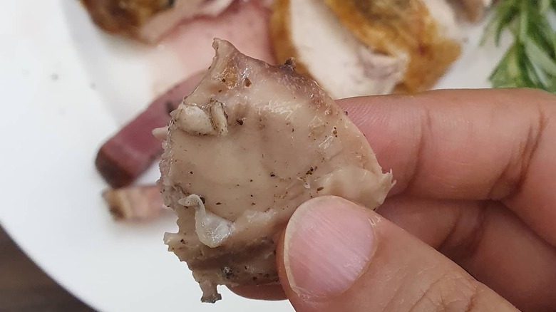 Fingers holding chicken oyster