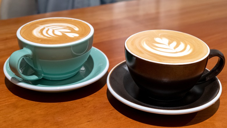 Two mugs of of coffee with latte art