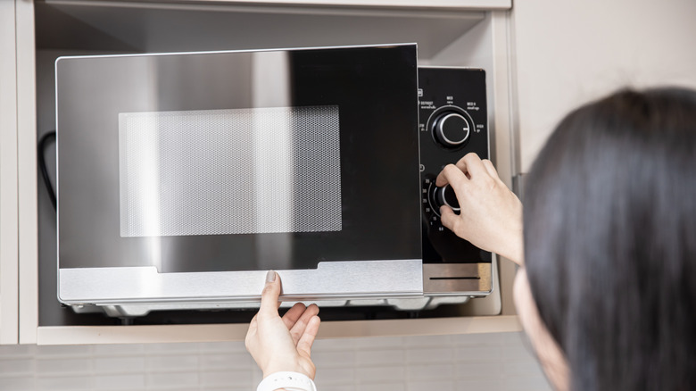 Woman opening microwave