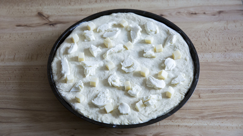 cheese distributed on pizza dough