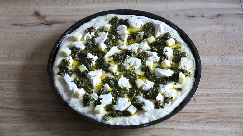 uncooked chimichurri pizza on table