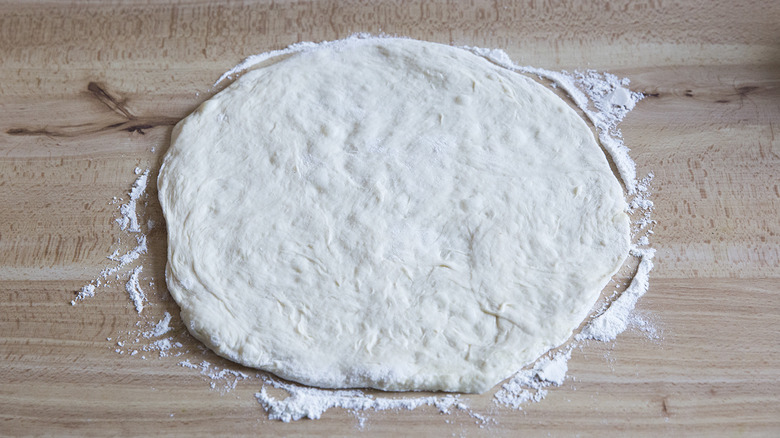 raw pizza dough on table