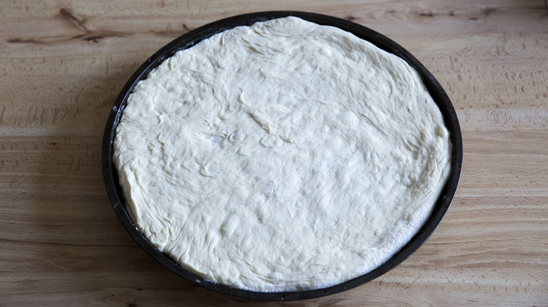 raw pizza dough in pan