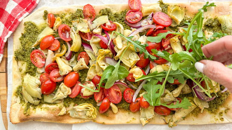 adding arugula to flatbread