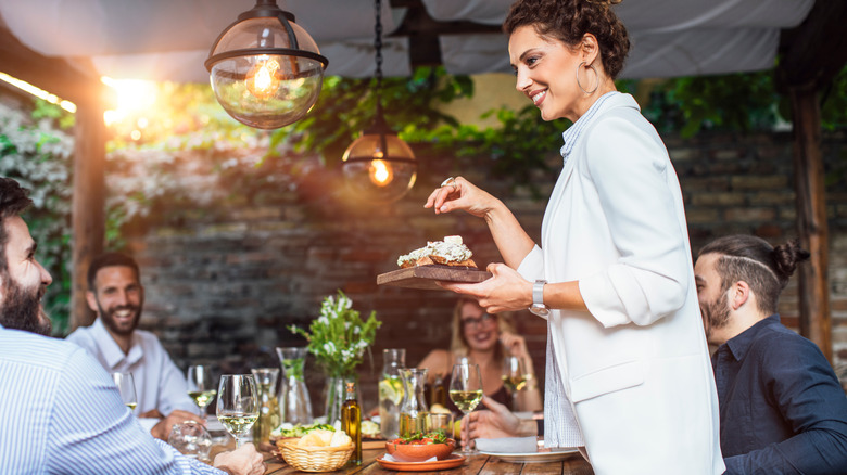 host serving food at party