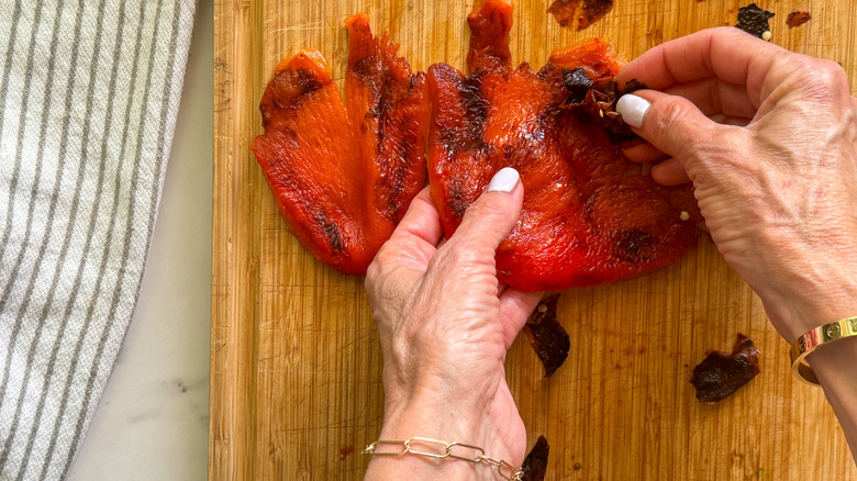 hands peeling red pepper skin