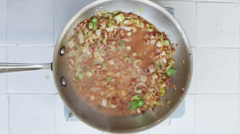 Vegetables and wine cooking in pan