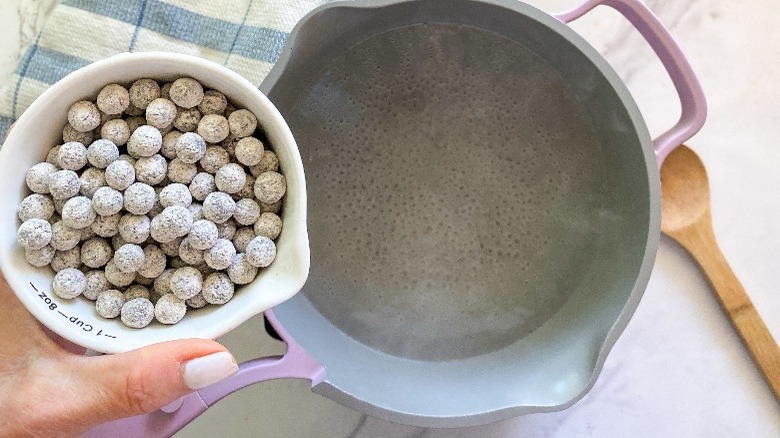 adding tapioca pearls to boiling water