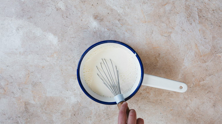 Whisking creamer in saucepan