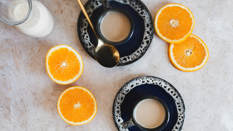 Bottle of creamer next to coffee and oranges