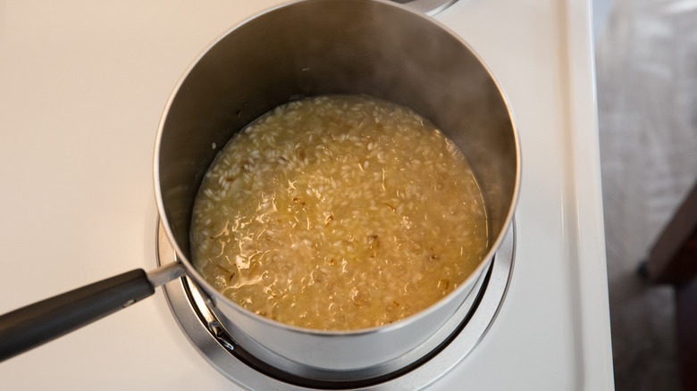 rice and broth in saucepan 