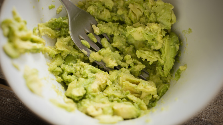 fork mashing avocado