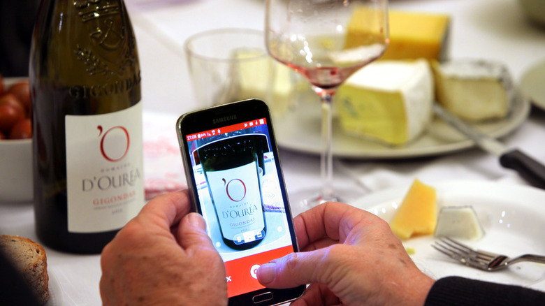 person scanning wine app bottle