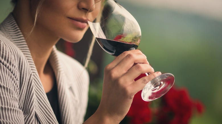 women smelling wine in glass