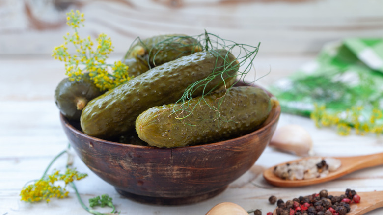 pickled cucumbers with spices and dill on light background