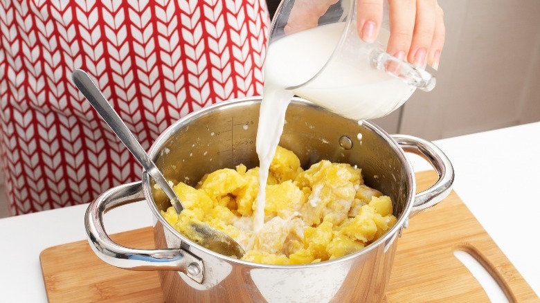 adding milk to mashed potatoes