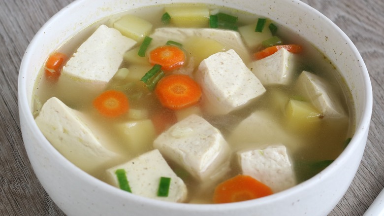 Tofu soup with vegetables in a white bowl