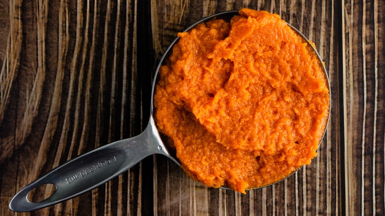 cup of pumpkin puree on a wood surface