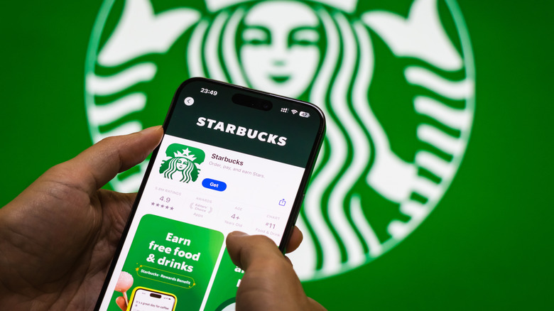 Person holding a smartphone with a Starbucks app