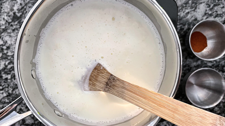 stirring milk with wooden spoon