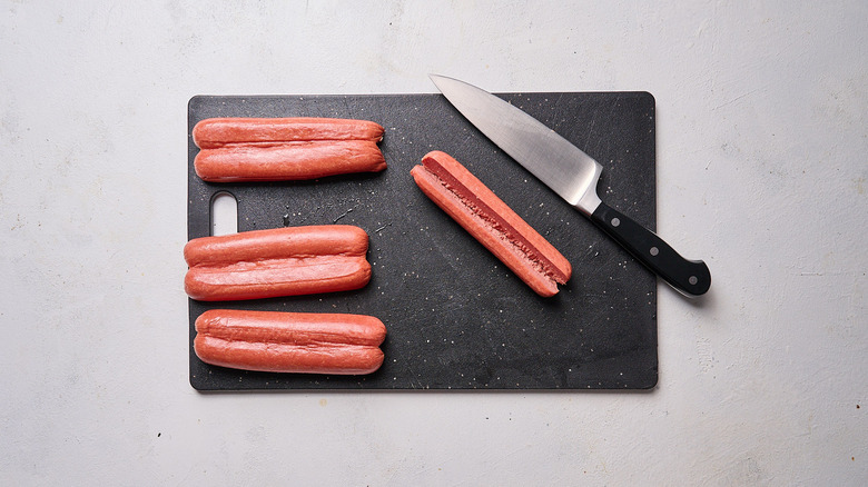 butterflied hot dogs on cutting board