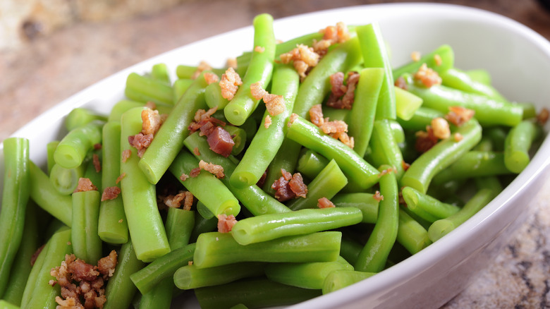 Close-up of green beans with bacon bits in a bowl 