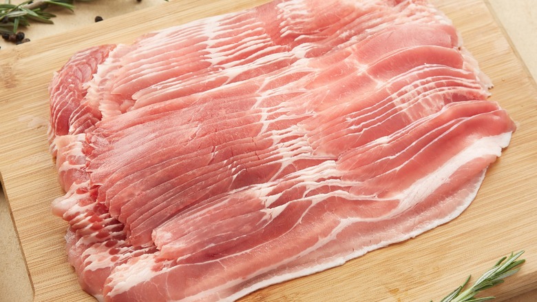 raw bacon on cutting board