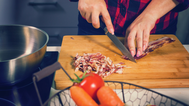 Home cook chopping bacon