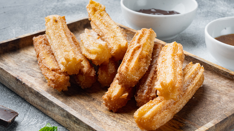 Churros with sugar on wood plate