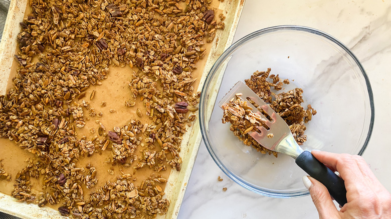 adding granola to bowl