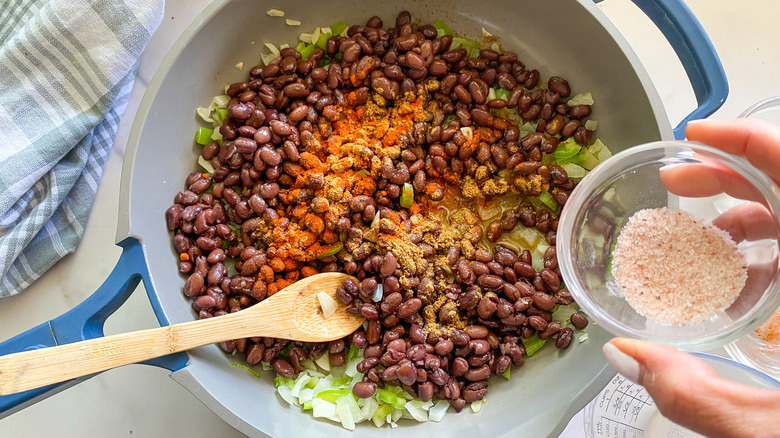 black beans with spices in frying pan