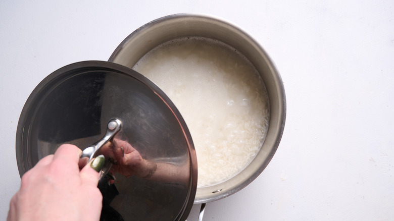 covering pot of rice with lid