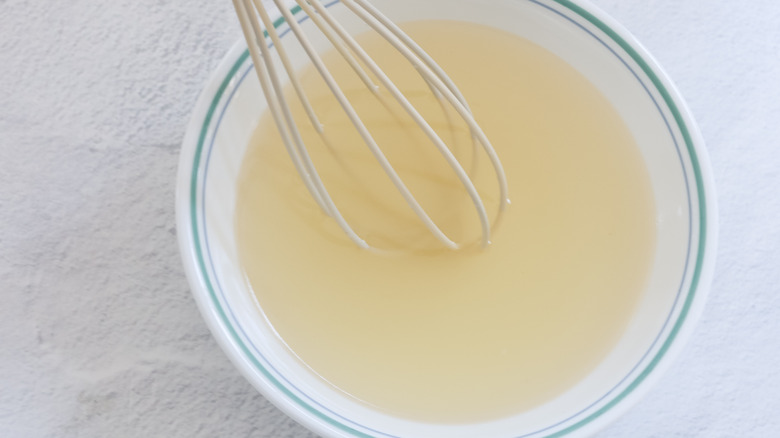 whisking lemon sauce in bowl