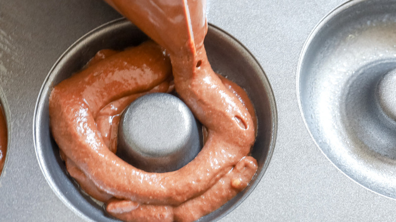 batter piping into donut pan