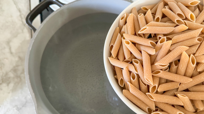 adding pasta to pot