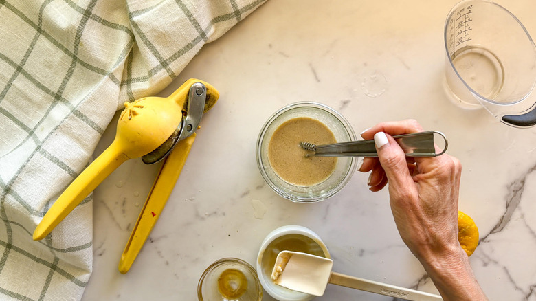 hand stirring dressing in bowl