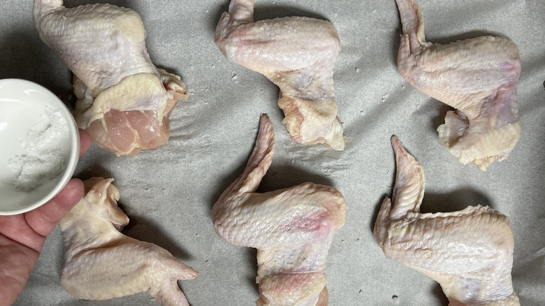 hand salting chicken wings