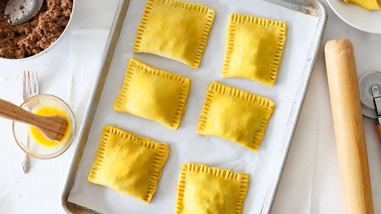 unbaked beef patties on pan