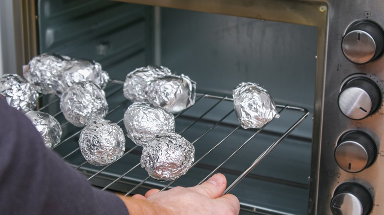 foil wrapped potatoes on oven grates