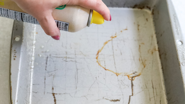 spraying oil in baking pan