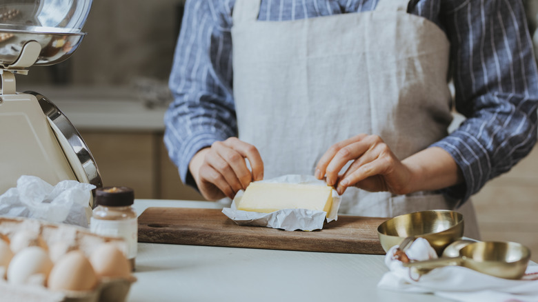 woman unwrapping stick of butter