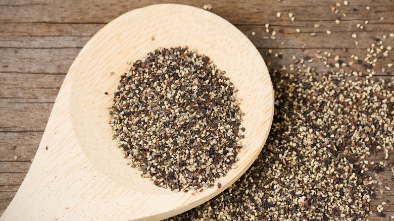 Black pepper on a wooden spoon