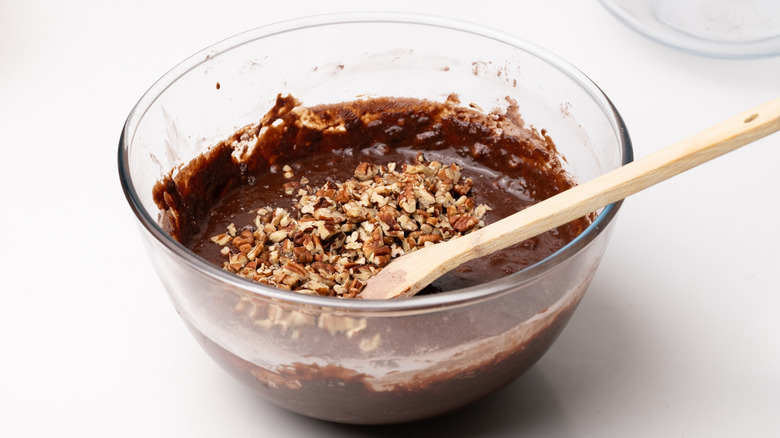 mixing pecans into brownie batter