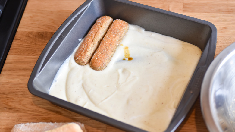 placing soaked ladyfingers in dish