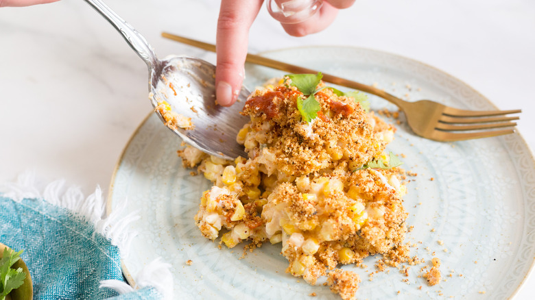 Putting a spoonful of casserole on plate