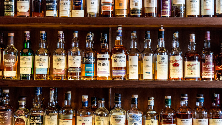 Shelves stacked with many different bottles of whiskey
