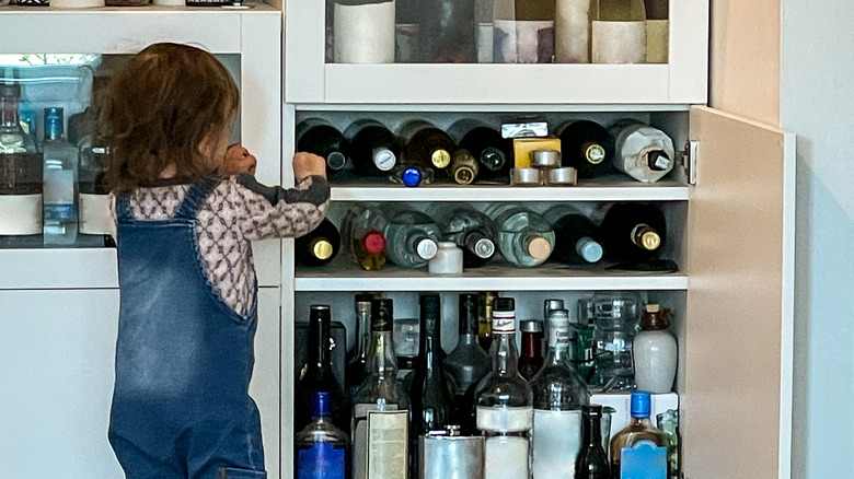 A child trying to access some liquor bottles