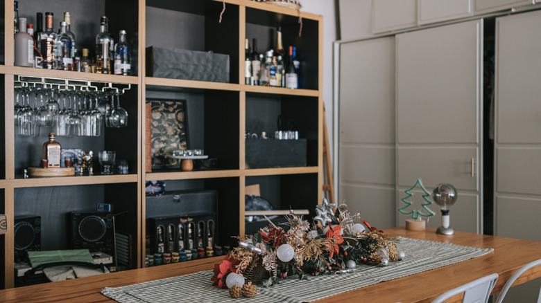 A bookshelf converted to store liquor bottles and other items