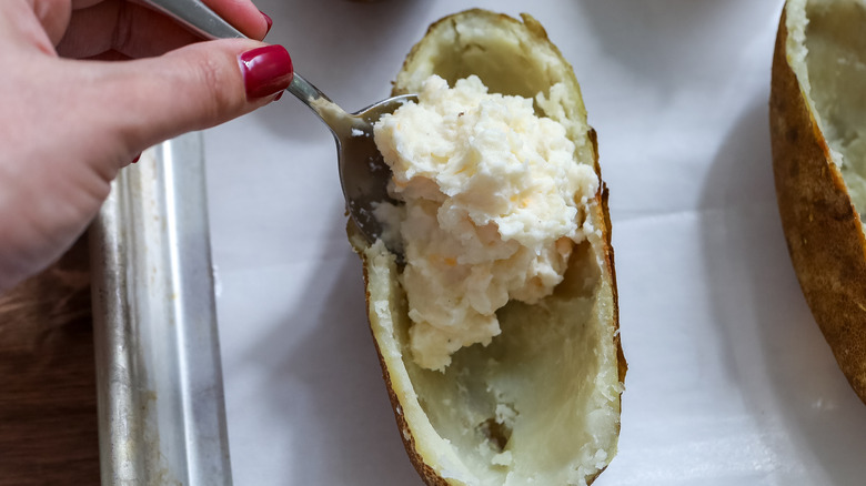 potato filling being scooped into potato skins